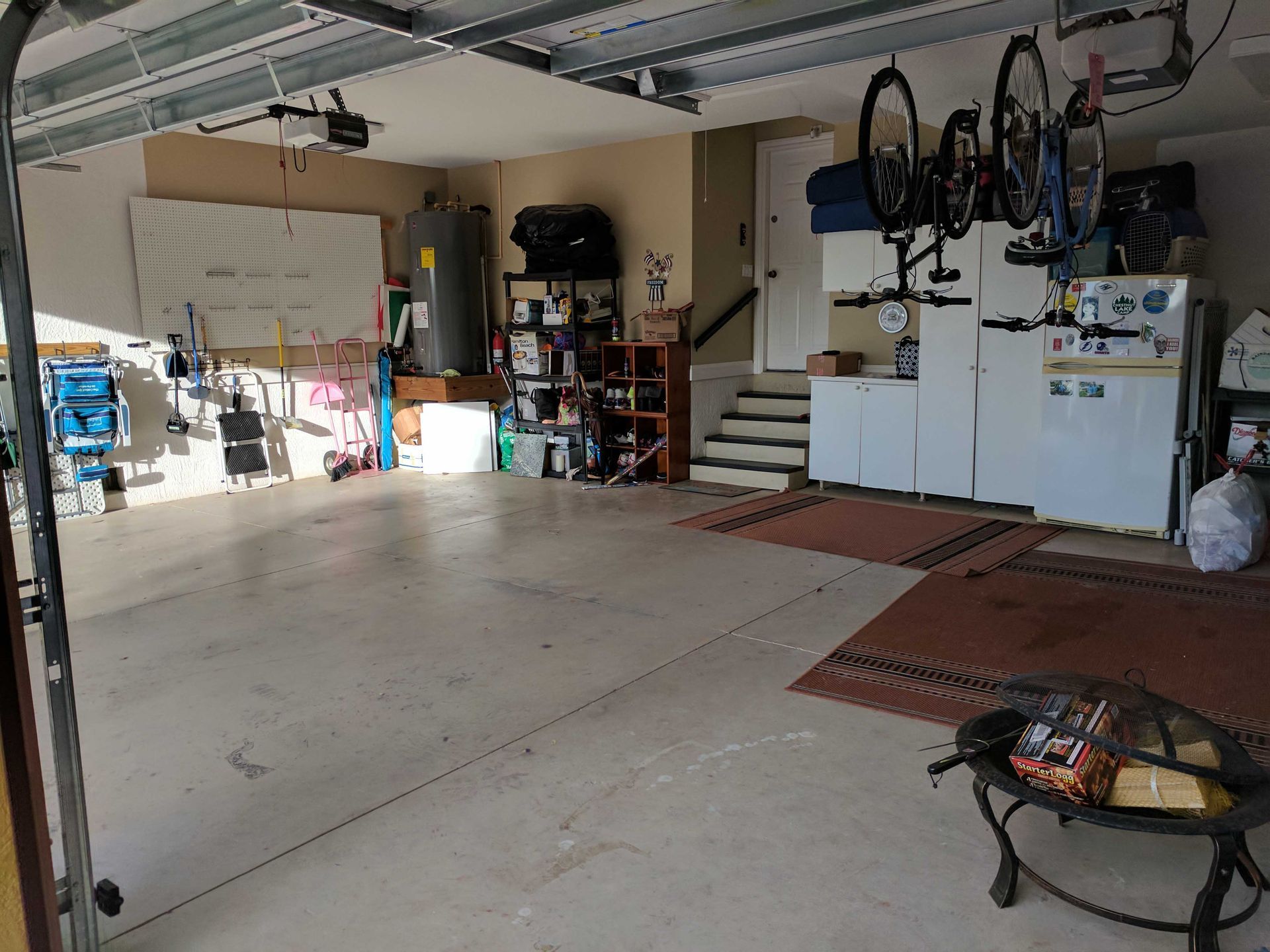 Garage interior with storage shelves, water heater, and bikes.