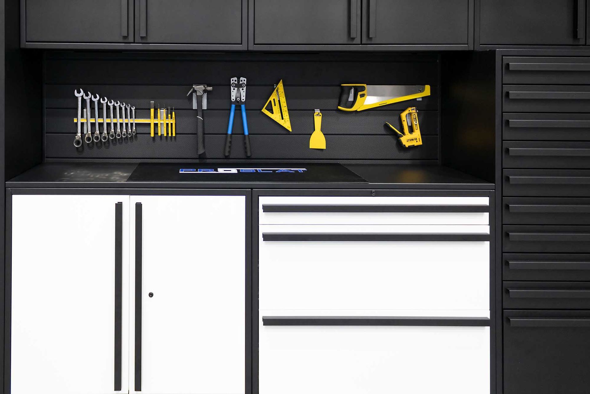Black and white garage storage system with tools on a pegboard and drawers.