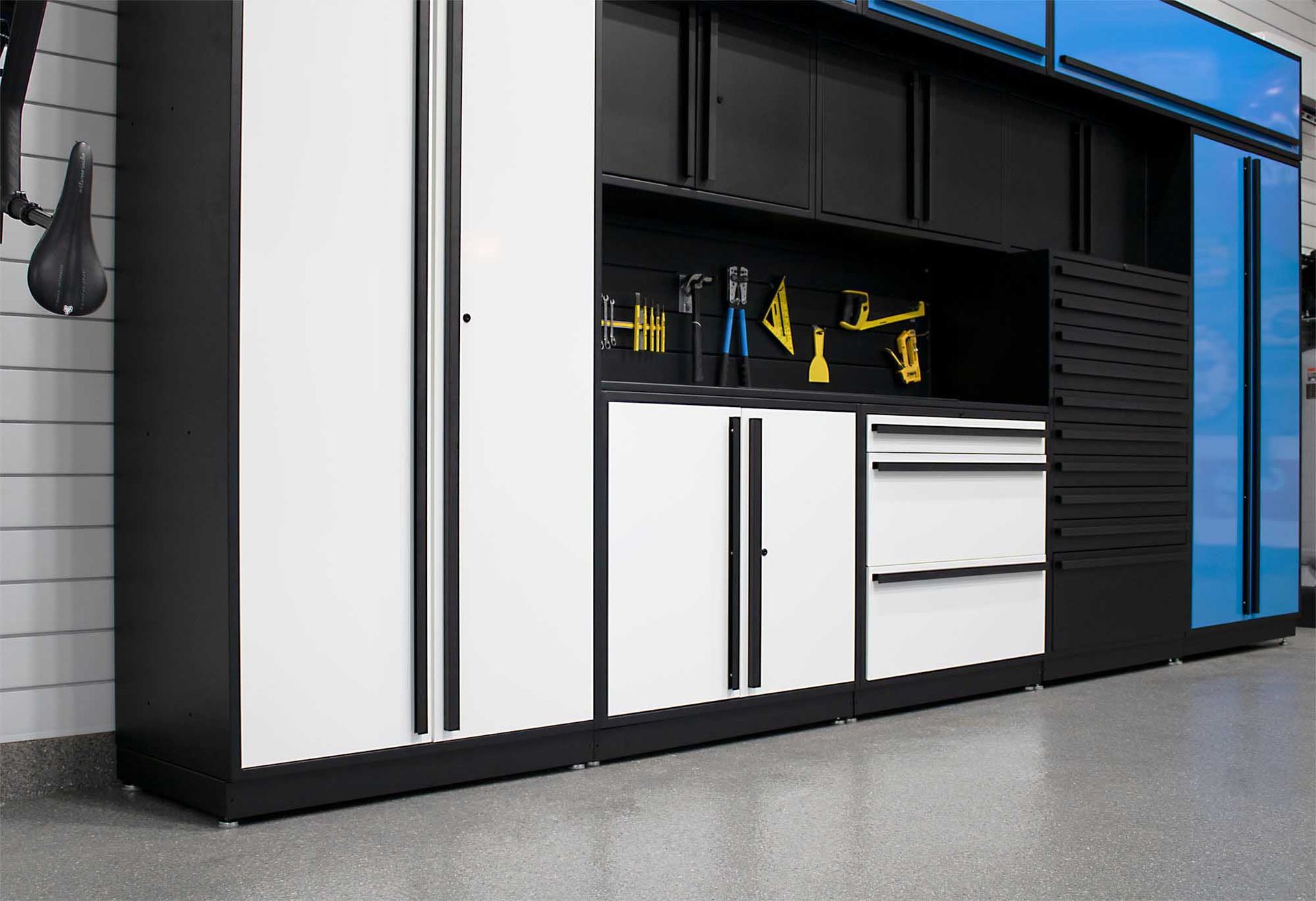 Garage storage cabinets, white and black, with tools and accessories.