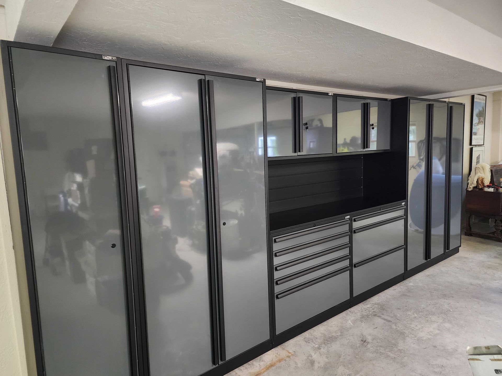 Garage storage cabinets in grey and black, mounted on the wall.