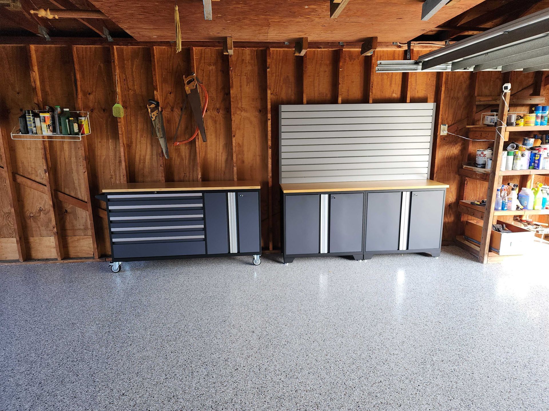 Garage interior with gray cabinets and speckled flooring.