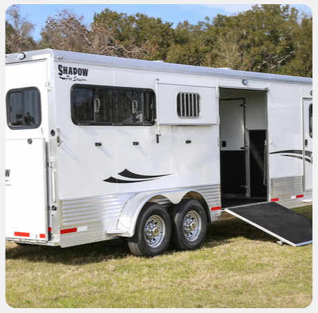 A white horse trailer with the word shadow on the side