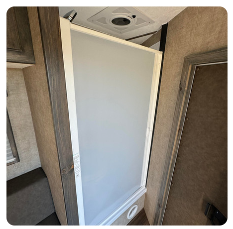 A bathroom with a shower stall and a door.