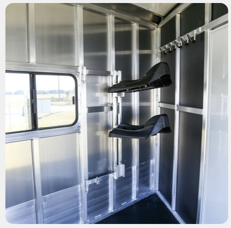 The inside of a horse trailer with saddle racks