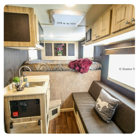 The inside of a camper with a bed and a sink