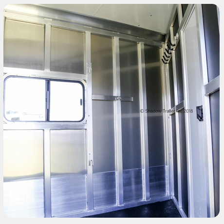 The inside of a trailer with stainless steel walls and doors