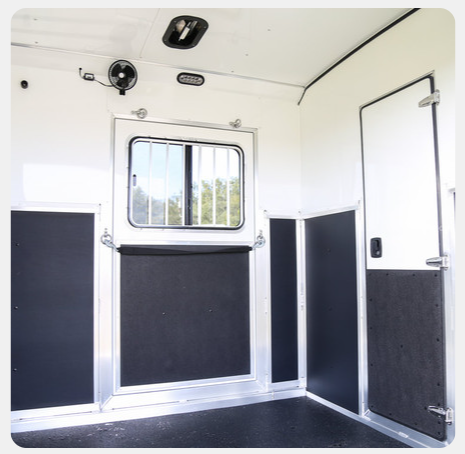 The inside of a trailer with a window and a fan
