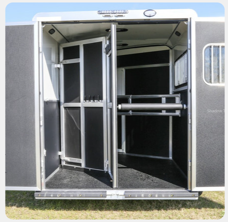 The inside of a horse trailer with the doors open
