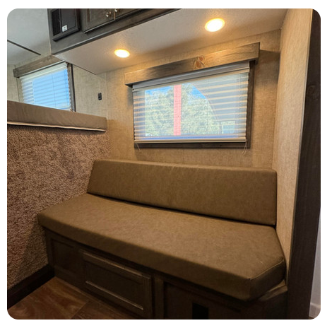 A room with a couch and a window with blinds