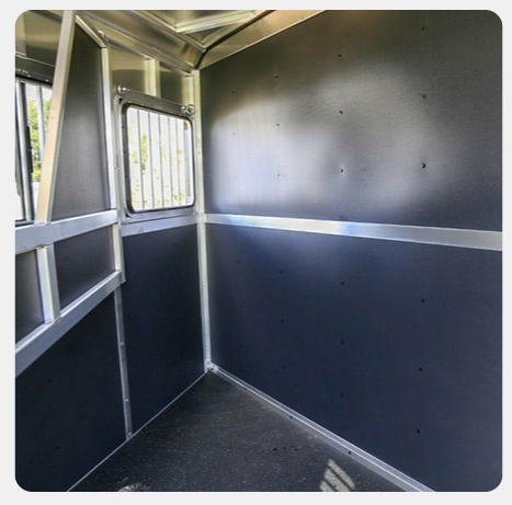 A picture of the inside of a horse trailer with a window