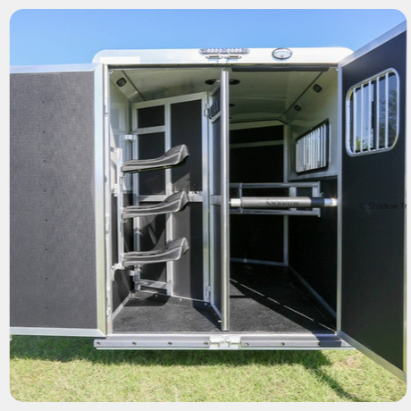 The inside of a horse trailer with the door open