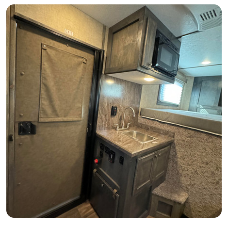 A kitchen with a sink and a microwave above it