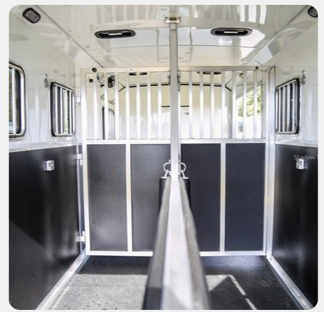 The inside of a horse trailer with black and white walls