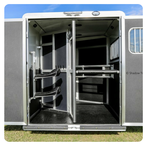 The inside of a horse trailer with the door open