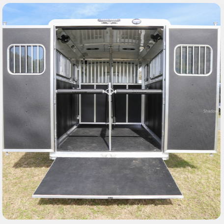 The inside of a horse trailer with the doors open