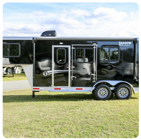 A shadow horse trailer is parked in a grassy field