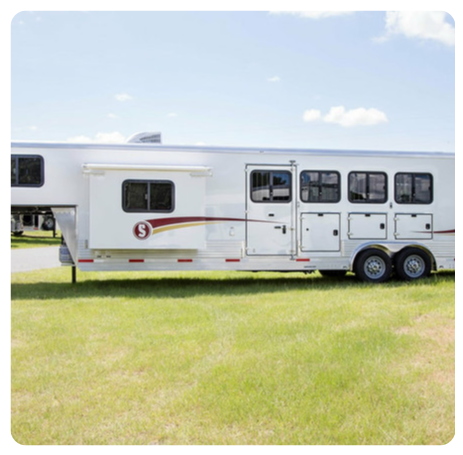 A white horse trailer with the letter s on the side