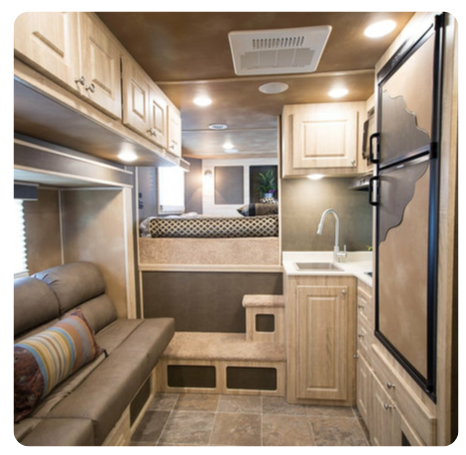 The inside of a rv with a couch and a refrigerator