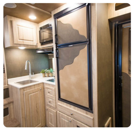 A kitchen with a sink a refrigerator and a microwave