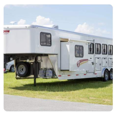 A white horse trailer with the word pow on the side