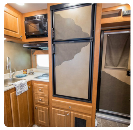 A kitchen with a refrigerator and a microwave