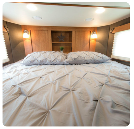 A bedroom with a bed and two pillows on it