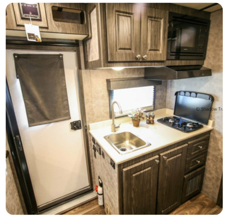 A small kitchen with a sink stove and microwave