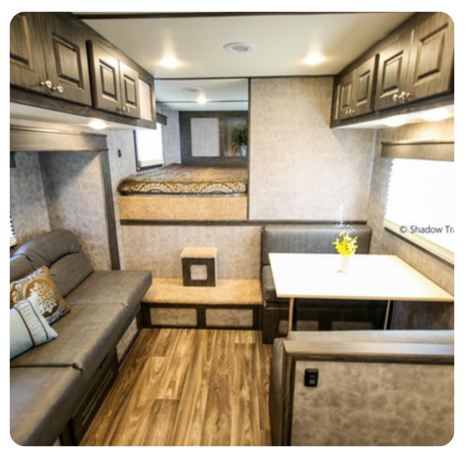 The inside of a rv with a table and couch