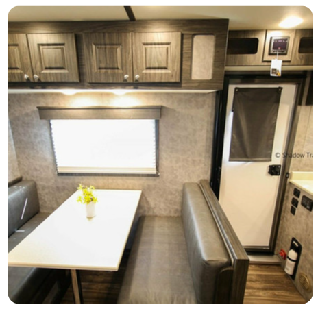 The inside of a camper with a table and a couch