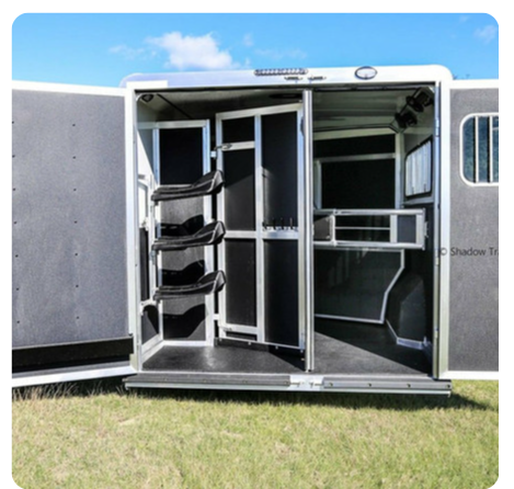 The inside of a horse trailer with the doors open