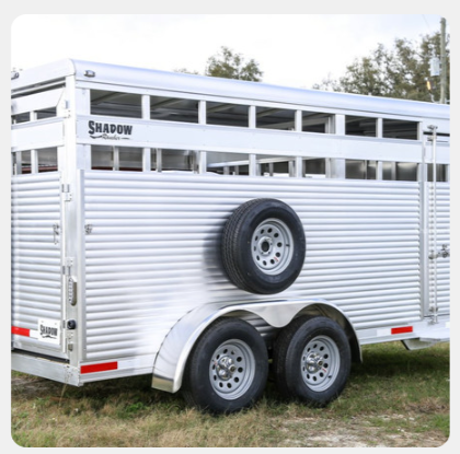 A shadow trailer is parked in a grassy field