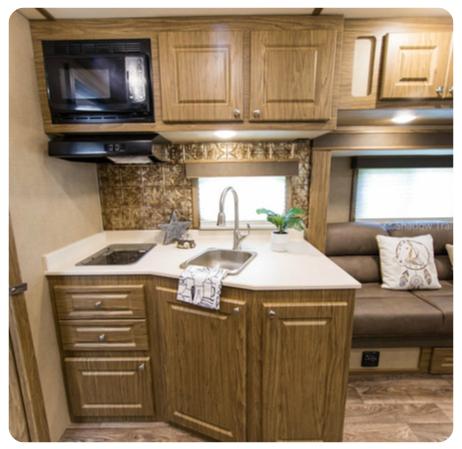 A kitchen in a rv with wooden cabinets and a sink