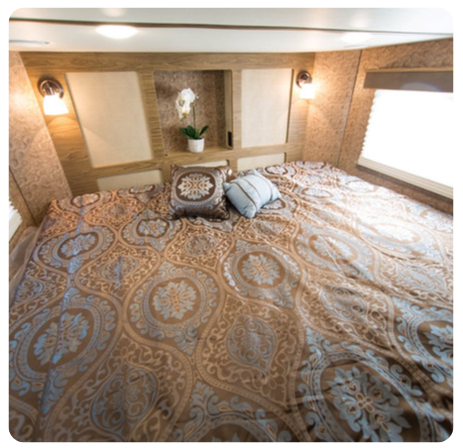 A bed with a patterned blanket and pillows in a room