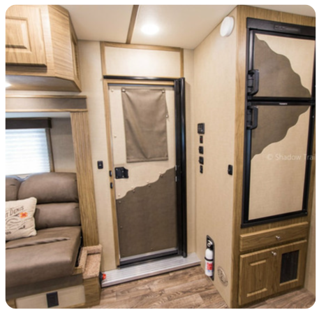 A picture of a rv with a couch and a door
