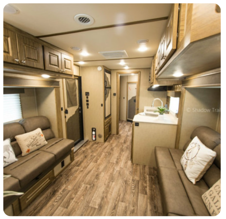 The inside of a rv with a couch and a kitchen