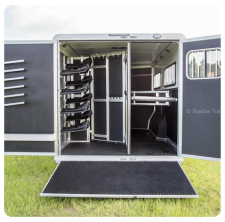 The inside of a horse trailer with the doors open