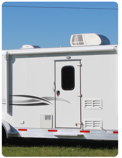 A white rv is parked in a grassy field