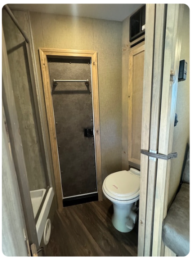 A bathroom with a toilet and a shower