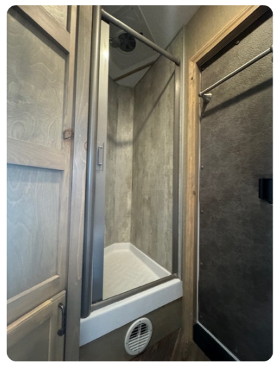 A bathroom with a shower and a screen door