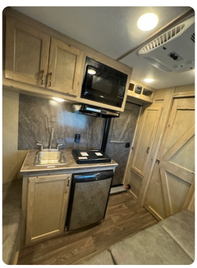 A kitchen with a sink a microwave and a refrigerator