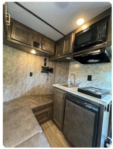 A kitchen with a sink a microwave and a refrigerator