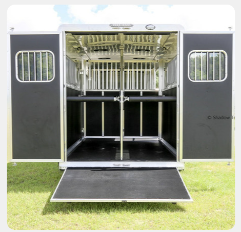 The inside of a horse trailer with the doors open