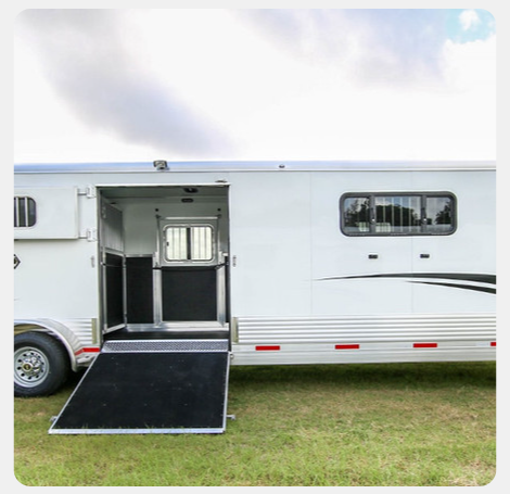 A white horse trailer with a ramp attached to it