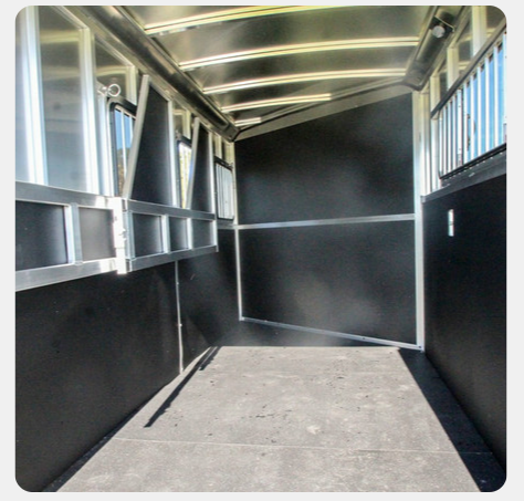 The inside of a horse trailer with a concrete floor