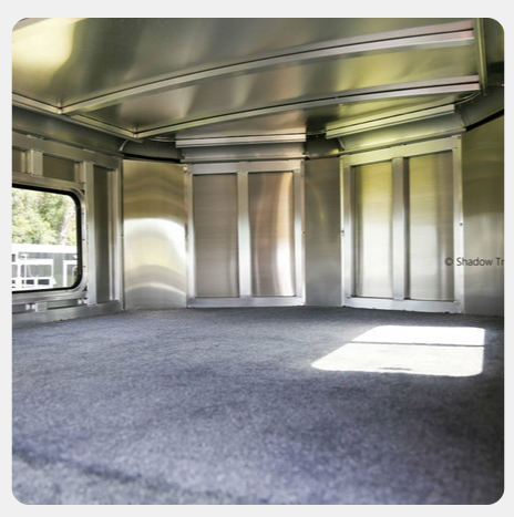 An empty room with stainless steel walls and a window