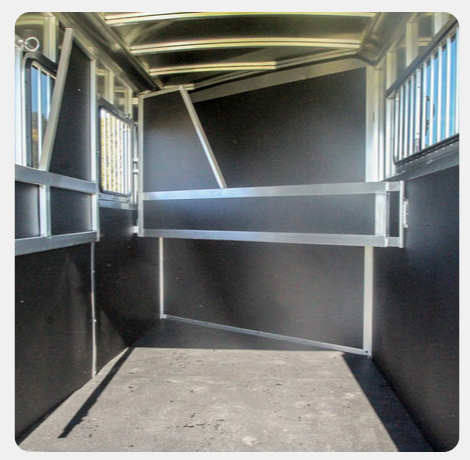 The inside of a horse stable with a concrete floor