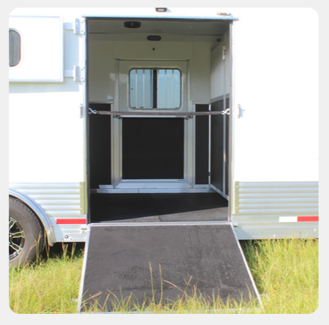 A white trailer with the door open and a ramp
