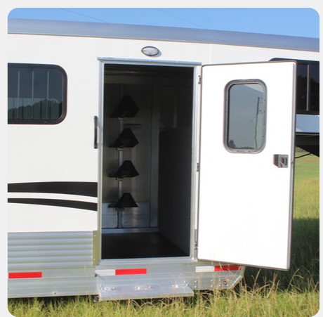 A white trailer with the door open in a field