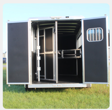 The inside of a horse trailer with the doors open