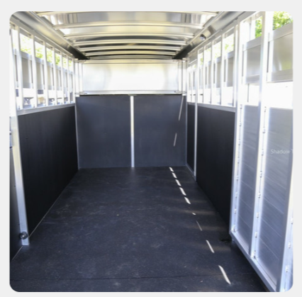 The inside of an empty trailer with a black floor